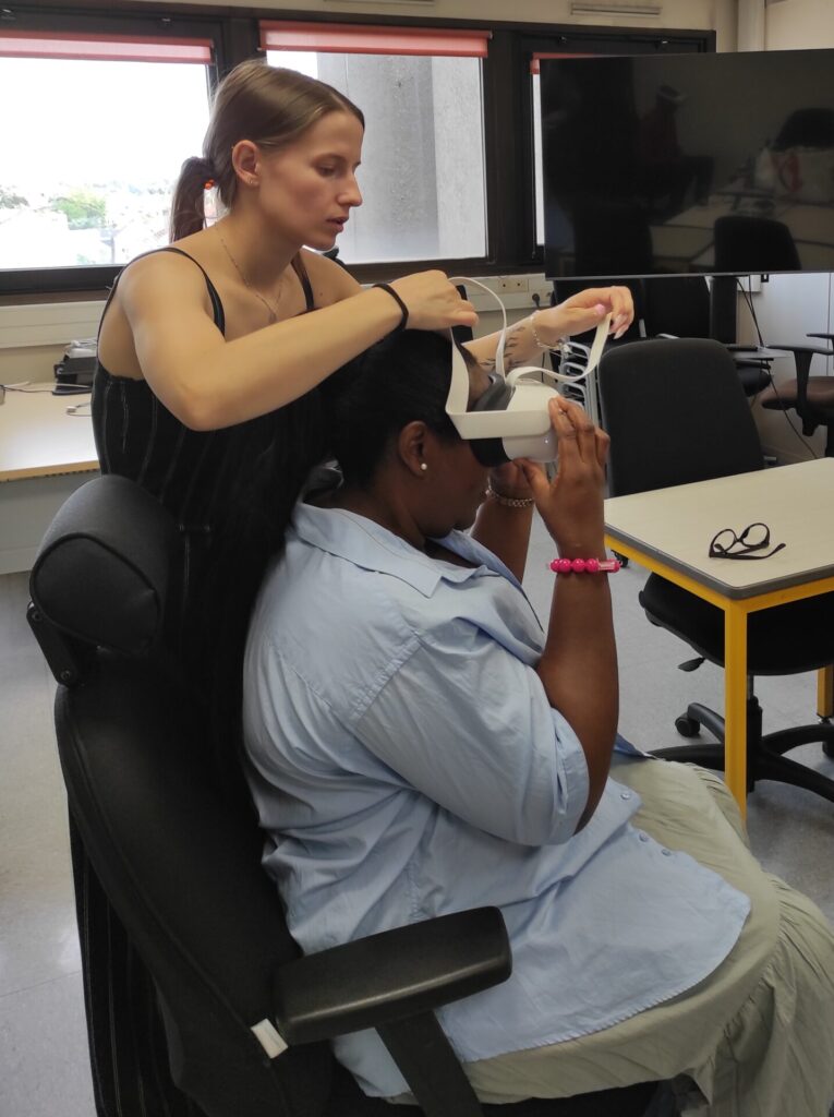 Une personne teste un casque de réalité virtuelle, accompagnée par une professionnelle lors d’un atelier